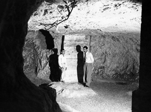 A view inside the Grotto, believed to be the cave in which Joseph and Mary Dwelt. A guide, left, relates the legend to a tourist as they stand by the remains of a stone table on Dec. 7, 1946 in Israel. The Grotto is situated beneath the modern Franciscan Church of St. Joseph’s, Nazareth. 