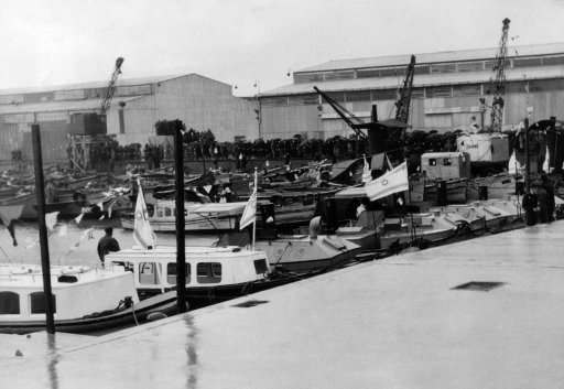 The lighter basin, with two big goods sheds in the background, at Tel Aviv, which took its place alongside the great port cities of the world when the high commissioner for Palestine, Sir Arthur Grenfell Wauchope, declared the “baby” port open for passenger traffic, during the ceremony, much of which had to be curtailed owing to heavy rain, a crowd with hoisted umbrellas can be seen in rear of the picture on Feb. 23, 1938. 