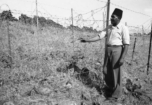 An Arab stands beside a section of ìTegartís Iron wallî in Israel in 1938, erected by Sir Charles Tegart to keep marauding Arabs out of Palestine. The fence, three strains of barbed wire on angular iron supports. Stretches for 60 miles on the Syria-Lebanon borders and cost $ 500,000. 