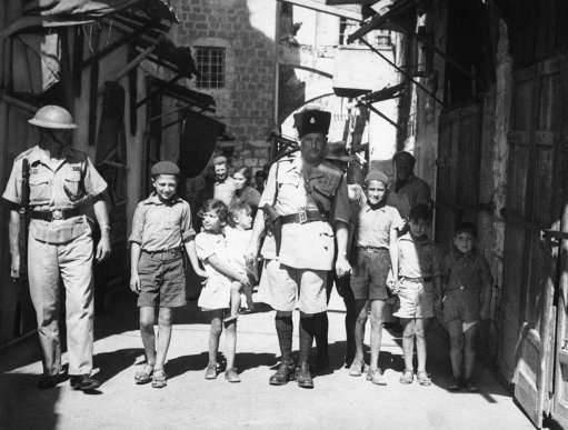 Since the British occupation of Jerusalem, Palestine, after the old city had been held for four days by Arabs, a measure of calm has descended on the district. Storm centre October 24óWhen this picture reached London by air after being was Jaffa, where there was sniping. British police captain leading Jewish kiddies to safety away from Arab snipers during the reoccupation of the old city of Jerusalem in Palestine, Israel on Oct. 24, 1938, by the British. 