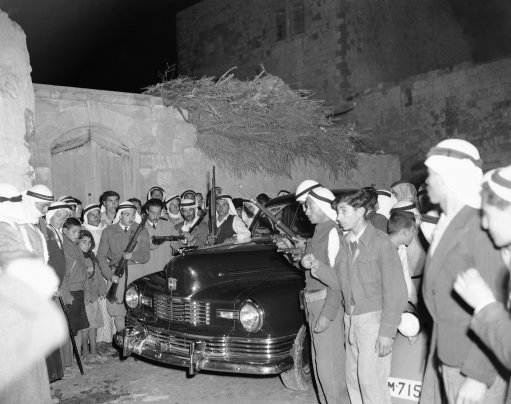 Armed Arabs surround the press car of American and British correspondents as the newsmen arrive at Taiba on a tour of Arab villages in Middle Palestine on Feb. 10, 1948. The correspondents encountered frequent roadblocks set up by the Arabs to keep a close check on traffic in fear of Jewish attacks.