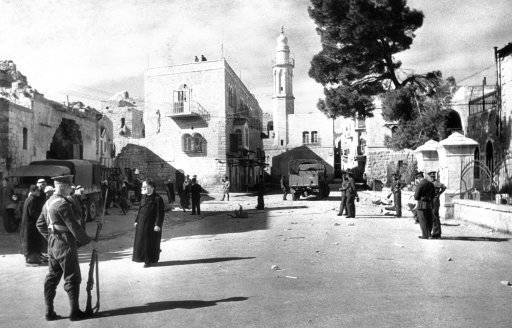 With a rifle at hand to stave off further attacks, this group of Jewish colonists, aided by Arab villagers, String barded wire in the 50 mile, tegarts wall, on the Palestine-Syria border on July 20, 1938 after bands of Marauding Arabs damaged the fence and engaged police in rifle fire. Arab bands and colonists have engaged with fatal result in clashes throughout July.