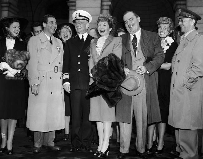 An honor guard of soldiers and Army and Navy officers greeted the 'Victory Caravan' of movie stars when they arrived at Union Station in Washington, April 29, 1942, for their first appearance on a tour for Army and Navy relief funds. Left to right are: Joan Bennett, producer Mark Sandrich, Charlotte Greenwood, in back, Rear Admiral Arthur J. Hepburn, Chief of the Navy Bureau of Public Relations, Claudette Colbert, Pat O'Brien, Joan Blondell, and Lt. Col. William Mason Wright, Jr., chief of the photographic section of the Army's Bureau of Public Relations. (AP Photo/Charles Gorry) 