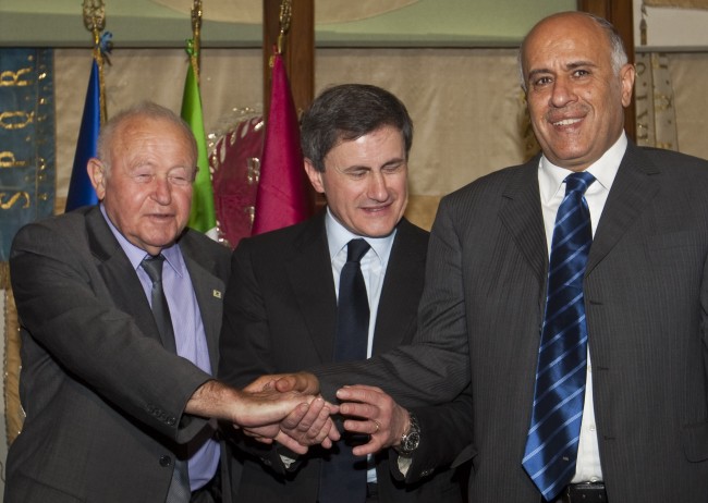 Rome's Mayor Gianni Alemanno joins the hands of Israeli Olympic Committee President Zvi Varshaviak, left and Palestinian Olympic Committee President Jibril Rajoub, right, at the end of a "Sports for Peace" press conference in Rome, Wednesday, April 20, 2011, where they issued pleas to build stronger ties. During the meeting arranged by International Olympic Committee vice president Mario Pescante, Palestinian Olympic Committee president Jibril Rajoub pushed for Israel to allow its athletes and coaches more freedom to travel from the West Bank and Gaza Strip. (AP Photo/Domenico Stinellis)