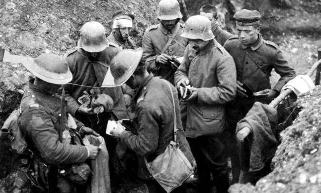 British troops sort through the belongings of German prisoners in a trench.