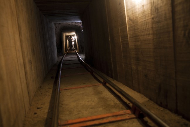 A news photographer walks inside a tunnel in the northern border city of Tijuana, Mexico Wednesday Nov. 30, 2011. A day earlier, the tunnel was discovered by U.S. authorities in San Diego's Otay Mesa area, the latest in a spate of secret passages found to smuggle drugs from Mexico. This tunnel is a 600-yard passage linking warehouses in San Diego and Tijuana and is equipped with lighting and ventilation. (AP Photo/Alex Cossio)