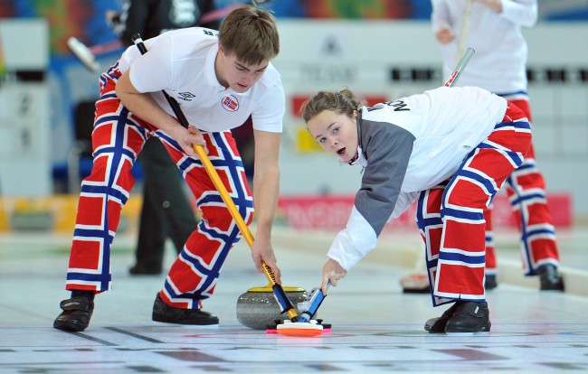 Norway's Martin Sesaker, left, and his teammate Stine Haalien work on the stone while playing against Estonia during a mixed team curling event at the first winter Youth Olympic Games in Innsbruck, Austria, Tuesday, Jan. 17, 2012. (AP Photo/Kerstin Joensson)