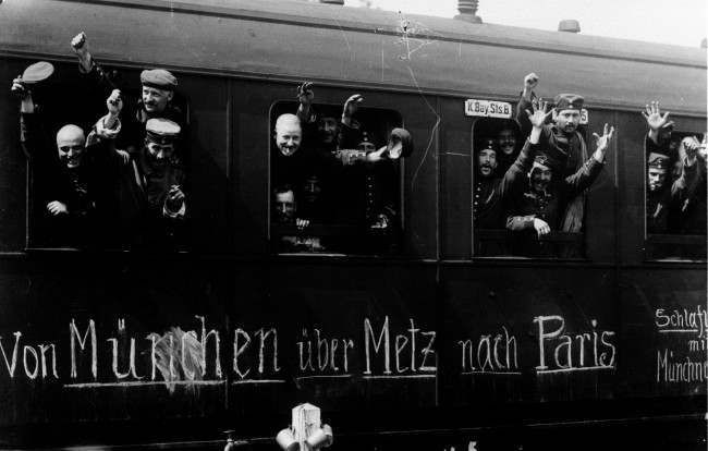 1915: Cheerful Bavarian soldiers of the German Army wave from their troop train as they leave Munich for the Western Front (via Metz) and, they hope, the fall of Paris.