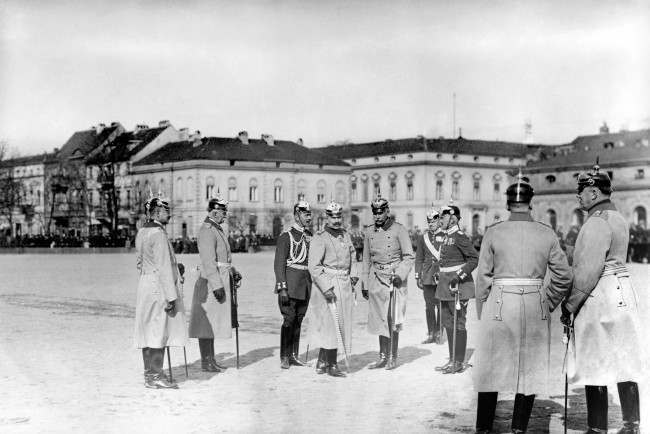Kaiser Wilhelm II stands with officers as he prepares to inspect a group of gunners who performed well in tests of marksmanship.