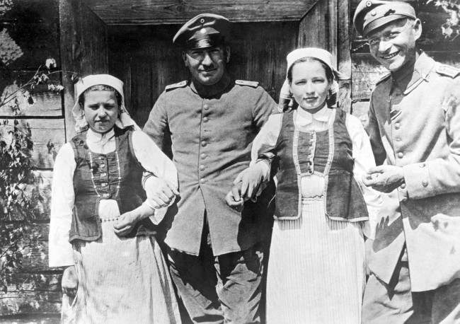 German soldiers arm-in-arm with two Polish girls.