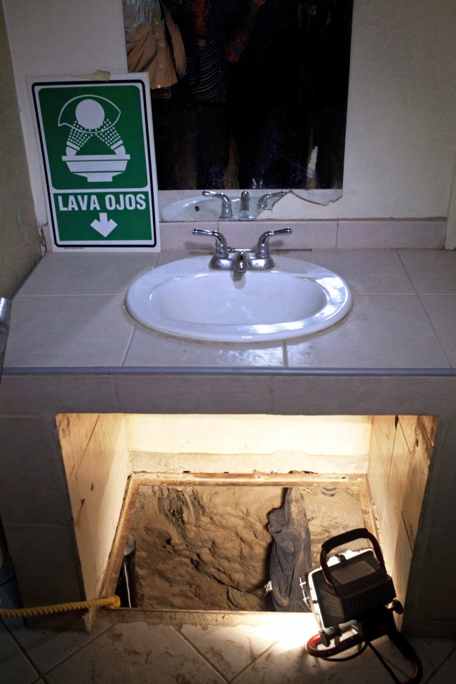 his July 12, 2012 file photo shows the entrance to a cross border illegal tunnel lit by a lamp after it was found underneath a bathroom sink by the Mexican army inside a warehouse in Tijuana, Mexico. More than 75 such underground passages have been found along the border since 2008, concentrated largely in California and Arizona. The job of searching these networks can be dangerous, so the U.S. Border Patrol is unveiling its latest technology in the underground war, a wireless, camera-equipped robot that can do the job in a fraction of the time. (AP Photo/Alejandro Cossio)