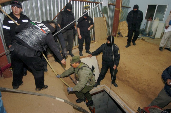 Soldiers use an elevator to descend journalists to a 9 meters deep (29 feet), 122 meters long (400 ft) tunnel found by the Army inside a house near the US-Mexico border in Tijuana, Mexico, Saturday, Nov. 7, 2009. Six suspects were arrested. (AP Photo/Guillermo Arias)