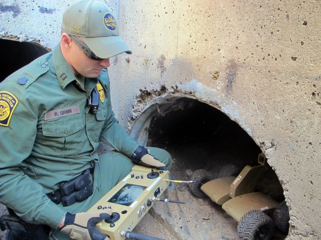 U.S. Border Patrol Agent Ryan Grimm demonstrates how a robot is used to navigate a drainage canal along the border fence during a briefing in Nogales, Ariz., Tuesday, Jan. 14, 2014. With more than 75 underground drug smuggling tunnels found along the border since 2008, mostly in California and Arizona, the Border Patrol is utilizing the wireless, camera-equipped robot, to search underground while keeping agents safer. (AP Photo/Brian Skoloff)