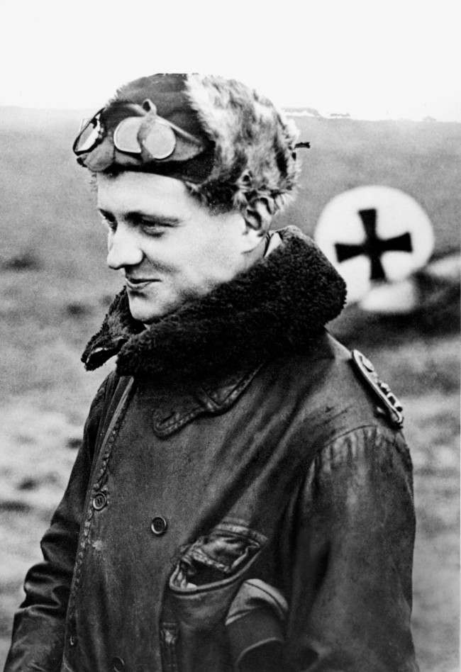 German airman Manfred von Richthofen, called the "Red Baron," is shown returning from a mission at his squadron's aerodrome at the Front in World War I in 1916. Behind him is the German Cross that marks his plane. (AP Photo)