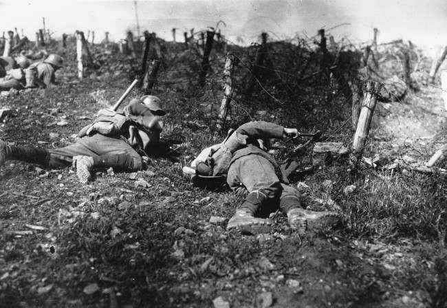 German troops stay close to the ground as one soldier uses pliers to cut barbed-fire fence during World War I. The location is unknown. (AP Photo)