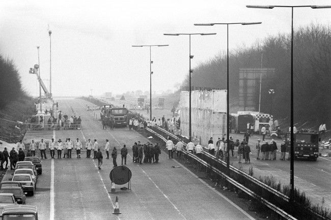 A line of police and soldiers spans the M1 motorway near Kegworth in Leicestershire to start a finger-tip search of the area around the crashed British Midland 737, which crashed just a few hundred yards short of the runway at East Midlands Airport. Date: 10/01/1989