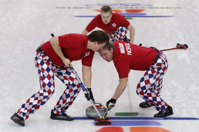 Norway's Christoffer Svae, left, and Torger Nergaard, sweep a stone delivered by Haavard Vad Petersson, top, in a win over China in men's curling at the Vancouver 2010 Olympics in Vancouver, British Columbia, Friday, Feb. 19, 2010. (AP Photo/Robert F. Bukaty)