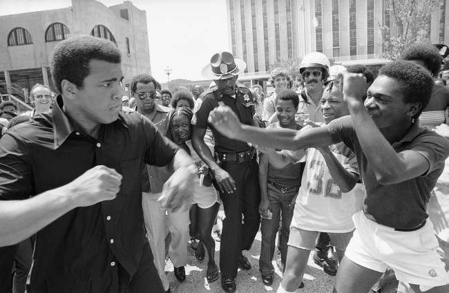 Muhammad Ali, left, playfully spars with a youth on Canal Street in New Orleans, July 31, 1978 where he is promoting his championship fight with Leon Spinks at the Superdome on September 15. Ali took a boat ride, paraded on Canal and then too a turn selling tickets. (AP Photo)