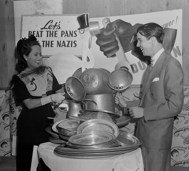 Merle Oberon, movie star, and Alfred G. Vanderbilt raise a din by beating pans at an aluminum-collection breakfast at the stork club in New York, July 23, 1941. The price of admission was a piece of aluminum ware. (AP Photo)