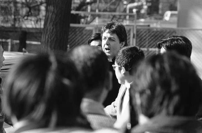 Former Beatle Paul McCartney calls a greeting to a handful of teenage fans who waited outside a drug investigation unit for his arrival in Tokyo on Jan. 17, 1980. McCartney, arrested after Customs officers found Marijuana in his luggage, spent the night in jail, was taken to the drug unit for questioning. (AP Photo/Sadayuki Mikami)