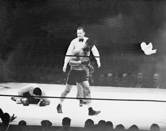 Heavyweight boxer Joe Louis walks away to a neutral corner as challenger Max Schmeling lies on the canvas in the first and final round of their 15-round rematch at Yankee Stadium in New York City, June 22, 1938. Schmeling's corner surrenders by throwing in a white towel into the ring at right. Referee Arthur Donovan called the match after 2 minutes and four seconds of action. (AP Photo)