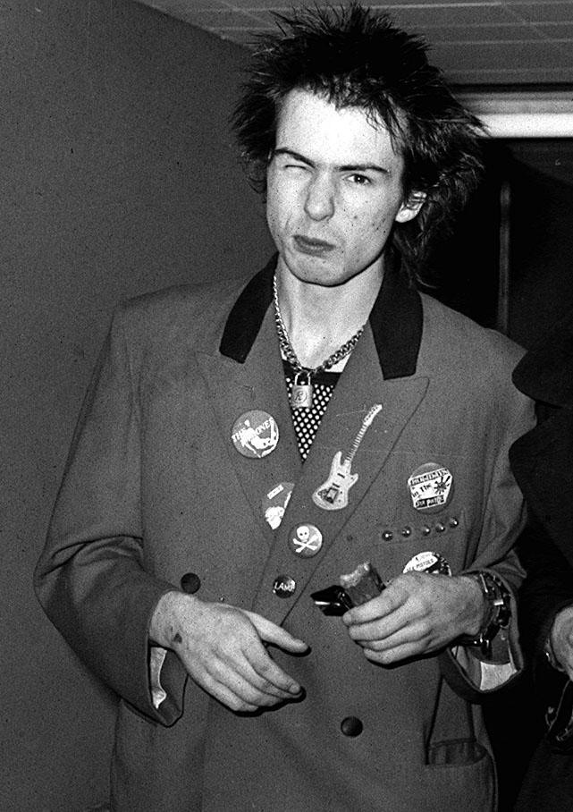 SID VICIOUS OF THE PUNK BAND THE SEX PISTOLS AT HEATHROW AIRPORT IN LONDON BEFORE LEAVING FOR LUXEMBOURG TO RECORD A SPECIAL PUNK ROCK PROGRAMME FOR RADIO LUXEMBOURG. AS THEY WALKED TO THEIR AIRCRAFT THEY HURLED ABUSE AT REPORTERS AND PHOTOGRAPHERS.  Date: 03/11/1977 