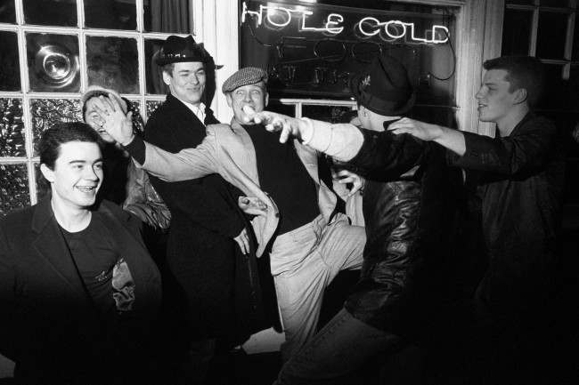 Madness with their first full length feature film, "Take It or Leave It", described as a documentary with music. The film features band members (pictured not in order), Bedders, Chas, Chrissy Boy, Lee, Mike, Suggs and Woody as themselves. Other parts are in the hands of actors. Take It or Leave It is titled after a track from the band's top twenty album.