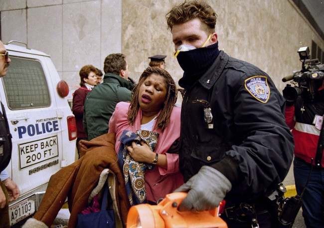  In this file photo of Feb. 26, 1993, a New York City police officer leads a woman to safety following a bomb blast at the World Trade Center. Twenty years ago a group of terrorists blew up explosives in an underground parking garage under one of the towers, killing six people and ushering in an era of terrorism on American soil.
