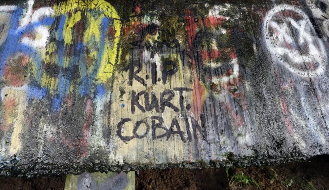 In this photo taken Monday, Sept. 23, 2013, graffiti, mostly written about Kurt Cobain, the late frontman of Nirvana, adorns the underside of the Young Street Bridge blocks from his childhood home in Aberdeen, Wash.