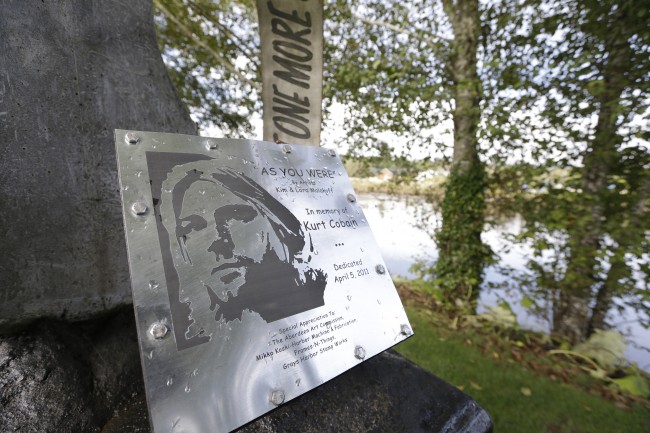 In this photo taken Monday, Sept. 23, 2013, a sign at "Kurt Cobain Landing," a tiny park blocks from the childhood home of Kurt Cobain, the late frontman of Nirvana, honors him as it overlooks the Wishkah River in Aberdeen, Wash. 