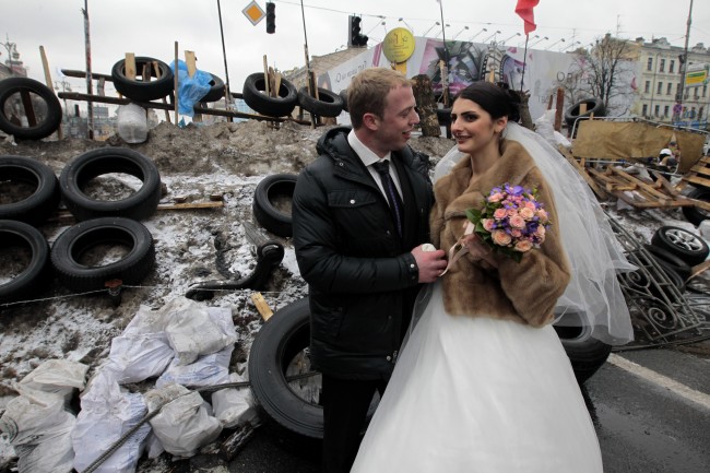 Newlyweds Mikhail and Margarita Nakonechniy share a tender moment in front of barricades on Independence Square, in a gesture of support for pro-Europe activists in Kiev, Ukraine, Saturday, Dec. 21, 2013.