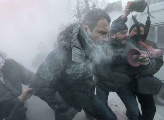 pposition leader and former WBC heavyweight boxing champion Vitali Klitschko is attacked and sprayed with a fire extinguisher as he tries to stop the clash between police and protesters in central Kiev, Ukraine, Sunday, Jan. 19, 2014. Hundreds of protesters on Sunday clashed with riot police in the center of the Ukrainian capital, after the passage of harsh anti-protest legislation last week seen as part of attempts to quash anti-government demonstrations. A group of radical activists began attacking riot police with sticks, trying to push their way toward the Ukrainian parliament building, which has been cordoned off by rows of police and buses.
