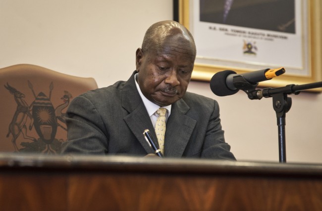 Uganda's President Yoweri Museveni signs a new anti-gay bill that sets harsh penalties for homosexual sex, in Entebbe, Uganda Monday, Feb. 24, 2014. Museveni on Monday signed the controversial anti-gay bill into law, with penalties including 14 years in jail for first-time offenders and life imprisonment as the maximum penalty for "aggravated homosexuality", saying it is needed to deter what he called the West's "social imperialism" promoting homosexuality in Africa. (AP Photo/Rebecca Vassie)