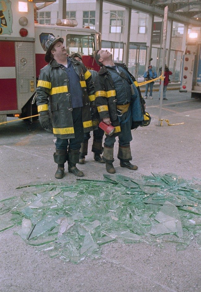 Three New York City firefighters look skyward in front of a pile of glass outside the twin towers of New York's World Trade Center, Feb. 27, 1993. An explosion rocked the center yesterday, killing at least five and injuring hundreds. 