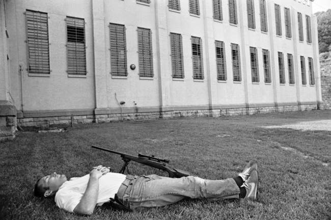 An unidentified sharpshooter at Brushy Mountain State Prison at Petros, Tennessee, June 11, 1977, takes a nap on the lawn in front of Cellblock after duty in the search for six escaped convicts. Hundreds of law officers search the mountains for the escapees, including James Earl Ray.