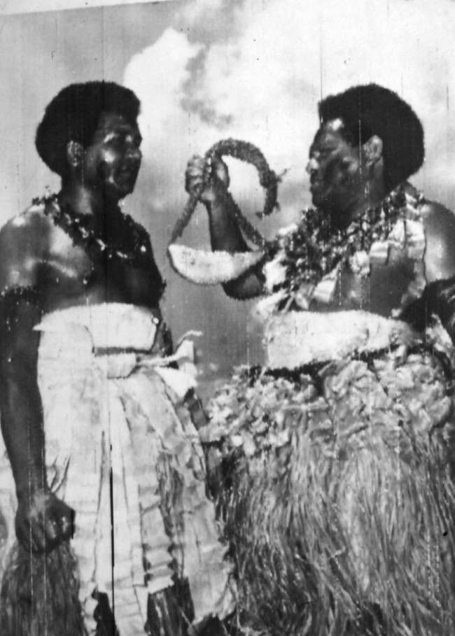 Fiji islanders Alfred Kikau and his brother Henry, with the whale's tooth (tabua) which they brought 80 miles by canoe across the Pacific to Suva to present to the Queen when she visits the islands during her Commonwealth tour. Date: 14/12/1953