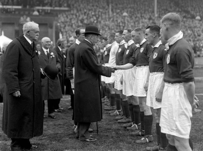 King George V attends the cup final at Wembley in 1930. He shakes hands with the Arsenal team before the start of the match. 