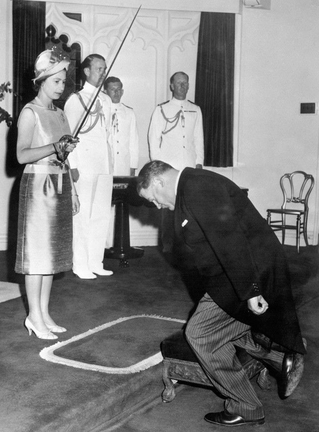 Queen Elizabeth II bestows the accolade of knighthood on the kneeling Sir Roy McCaughey of New South Wales, at Government House, Sydney.