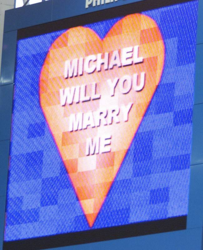 Valentine's Day came early for a Chelsea-mad football fan whose girlfriend marked his first ever visit to Stamford Bridge by proposing to him in front of 30,000 fans. Amanda Kirk, 22, popped the question on the club's giant scoreboard. * 30-year-old Michael Evans said Yes as soon as he had got over the shock. For design engineer Mr Evans it was a triply special day. It was his first ever match at the home of the Blues, despite being a lifelong fan.Then came Amanda's half time proposal. And to top it all, his beloved team ran out 3-1 winners over London rivals Wimbledon. Mr Evans and Miss Kirk travelled to London with his daughter Leanne from their parents' homes in South Wales. 