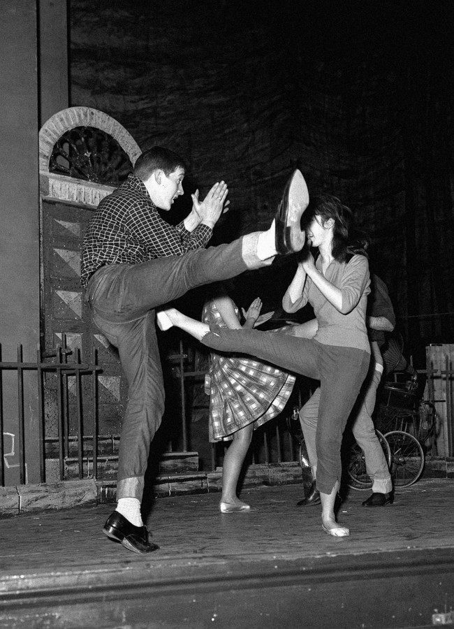Billy Boyle and Audrey Carr dancing a vigorous Twist on the stage of the Garrick Theatre in London during a rehearsal of "The Scatterin'" an Irish play by James McKenna, opening at the Theatre Royal in Stratford. Billy Boyle, an 18-year old variety star is billed in Ireland as "Dublin's teenage idol". Boyle played a minor role so well in the original production at the 1960 Dublin Theatre Festival, that he was chosen by director Alan Simpson for a leading part in the London production. The play's story centres on four Dublin boys, is told in dialogue and in over 20 musical numbers ranging from traditional ballads though rock 'n' roll, to the Twist.