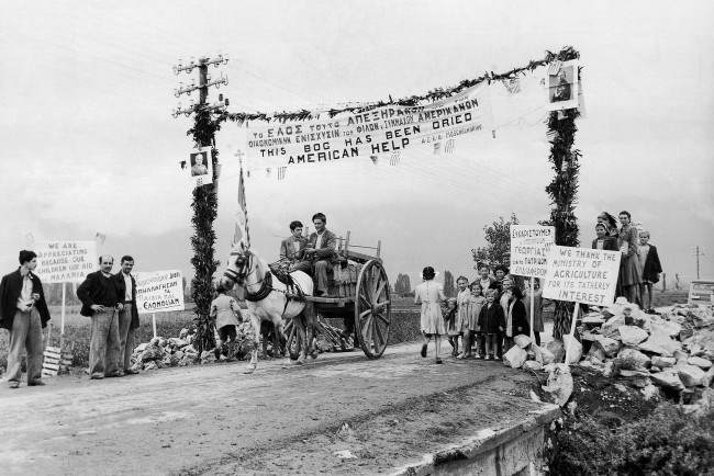 This arch outside Anthele, Greece on Nov. 14, 1946, is decorated with slogans thanking America for her help in farm development and for clearing malaria breeding grounds. A picture of President Harry Truman is on the post left. 