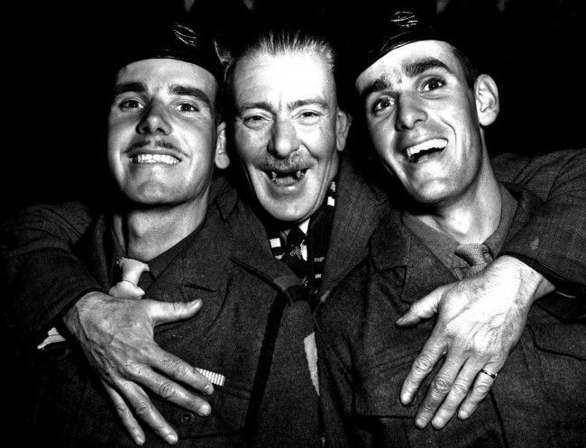  A happy reunion at Southampton as the trooper Empire Orwell returns with 750 British servicemen from Korea, Clasping his twin sons (21) is ex-CSM George Wood. His sons are Donald (left) and Ronald, members of the 7th Royal Tank Regiment.  Date: 09/11/1951 