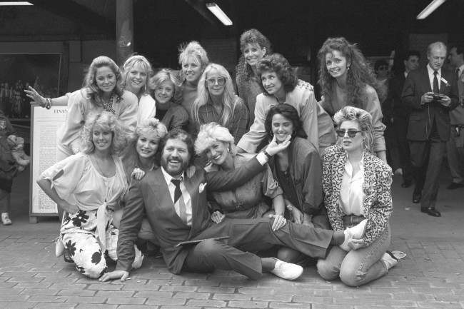 DJ Dave Lee Travis is surrounded by some of the women who appear in his photography book A Bit of a Star. Back Row L-R: Unidentified, Janet Ellis, Rosalind Ayre, Sarah Greene,Georgina Hale, Diane Keen, Jan Leeming, Cherry Gillespie. Front Row L-R: Jane Warner, Debbie Arnold, Dave Lee Travis, Faith Brown, Unidentified, Kim Wilde. Date: 27/05/1986 