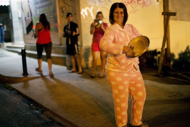 A woman wearing her pajamas bangs on a pot during an anti-government demonstration in the Altamira neighborhood of Caracas, Venezuela, Friday, Feb. 21, 2014. The anti-government movement has appeared to have snowballed into a political crisis, the likes of which Venezuela's socialist leadership hasn't seen since a 2002 coup attempt. Protest rallies are expected throughout the country on Saturday. 