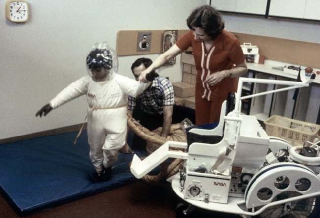 With help from his parents, David Vetter 6, of Houston, walks for the first time outside the isolation bubble he has lived in all his life. David is wearing a germ-free suit called the Mobile Isolator System developed by NASA in cooperation with the Texas Children Hospital at an estimated cost of $20,000. David was born with severe combined immune deficiency. The cart carries a life-support system and a chair for David. (AP Photo/NASA) Date: 10/04/2008