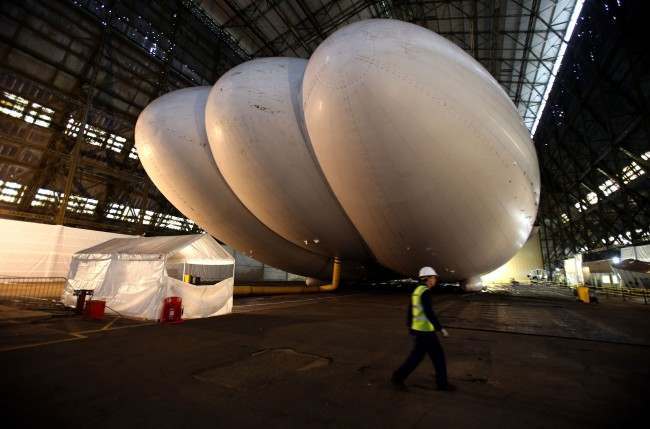 A workman walks past the world's largest aircraft known as the HAV304, at its launch at Cardington Hanger in Bedfordshire. Picture date: Friday February 28, 2014. 