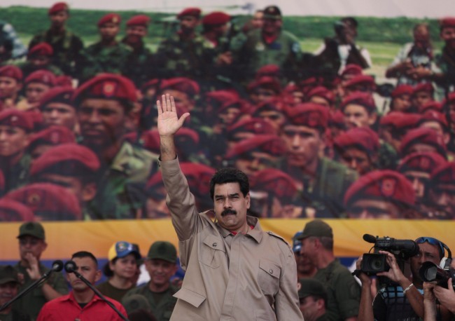 Venezuela's President Nicolas Maduro waves to supporters during a march in honor of Venezuela's Army and National Guard, in Caracas, Venezuela, Saturday, March 15, 2014. The Venezuelan government is stepping up security operations in Caracas and other cities where demonstrators are blocking streets, avenues and highways. Maduro said that those involved in creating road barricades will be arrested. 