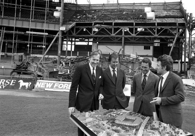 (L-R) Roger Bannister, Chelsea chairman Brian Mears, Chelsea manager Dave Sexton and architect John Darbourne examine a model of the proposed new developments at Chelsea's Stamford Bridge home, whilst demolition of the old stands continues in the background Ref #: PA.2935316  Date: 05/06/1972
