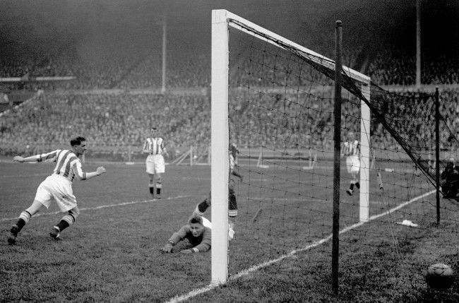 Huddersfield Town goalkeeper Hugh Turner (c) is beaten by Arsenal's first goal, scored by Alex James (not in pic)