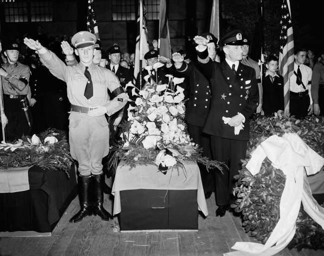 German Nazis give the salute as they stand beside the casket of Capt. Ernest A. Lehmann, former commander of the zeppelin Hindenburg, during funeral services held on the Hamburg-American pier in New York City. 